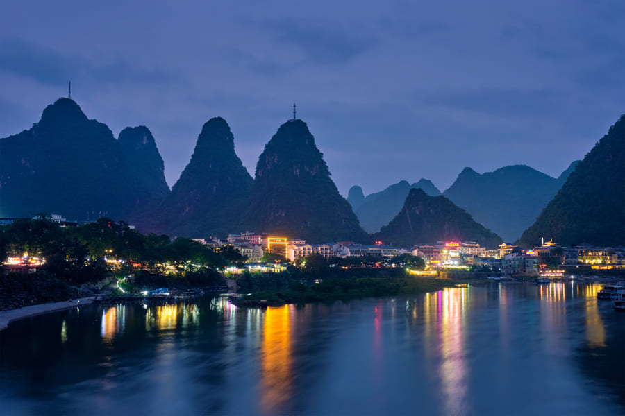 Vista nocturna de Yangshuo, China, con las montañas kársticas y el río Li iluminando uno de los paisajes más famosos del país.
